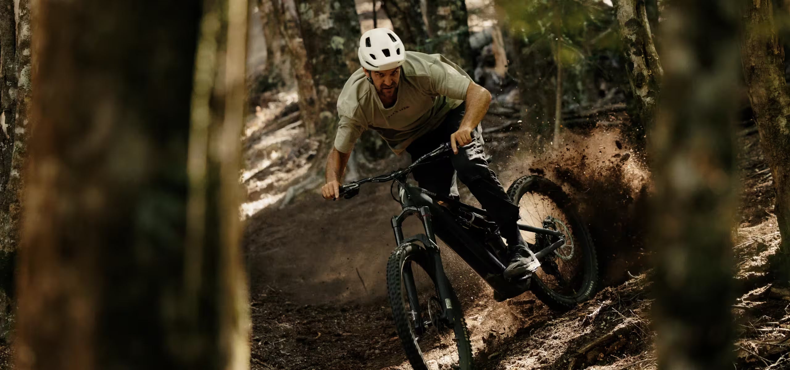 Man riding a mountain bike through a forest trail