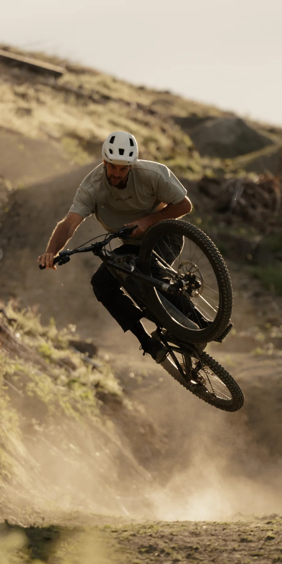 Person riding a mountain bike on a dirt trail with a helmet.