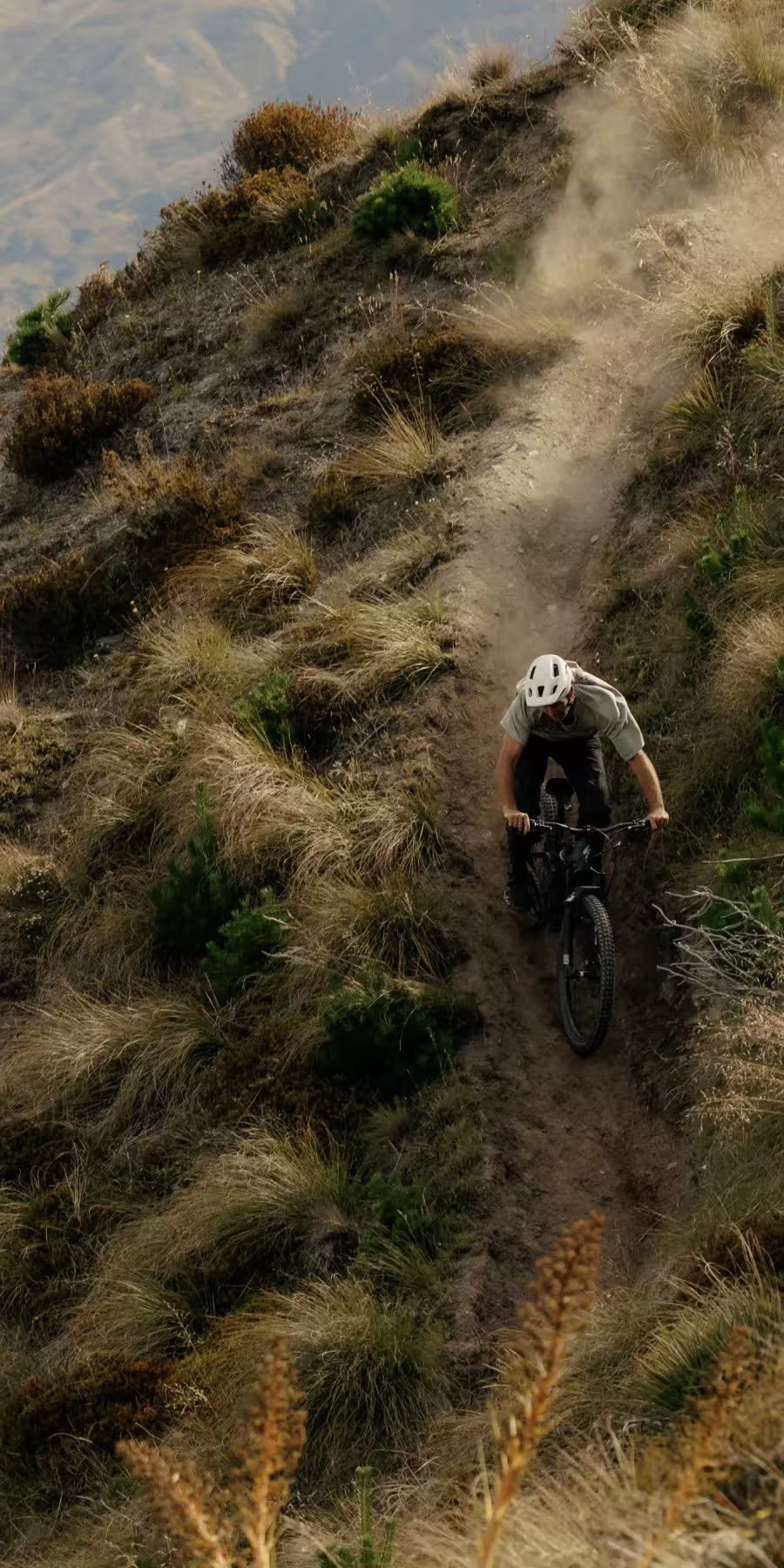 Person riding a mountain bike on a dirt trail in a natural landscape
